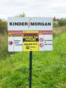 Sign saying. Kinder Morgan. Danger No Trespassing. Warning Natural Gas Pipeline. Danger No Smoking or Open Flame